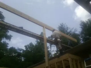 Carpenter setting a ridge beam over a new addition frame in Liberty Lake