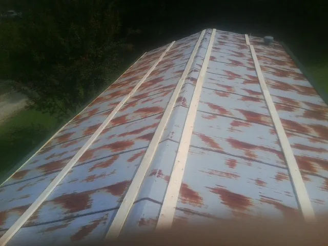 Rusted metal roof panels with new wood purlins before replacement — Storm Damage Roof Repair in Liberty Lake by Roofing Brothers