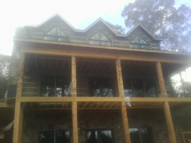 Dormers and porch framing on a large log home under construction — Roof Coating work by our crew in Liberty Lake