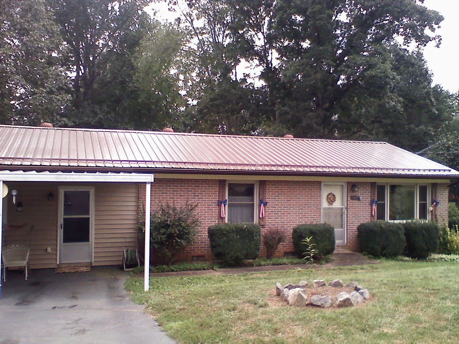 Bronze metal roof and carport on a brick ranch home — Roof Repair work by our crew in Liberty Lake